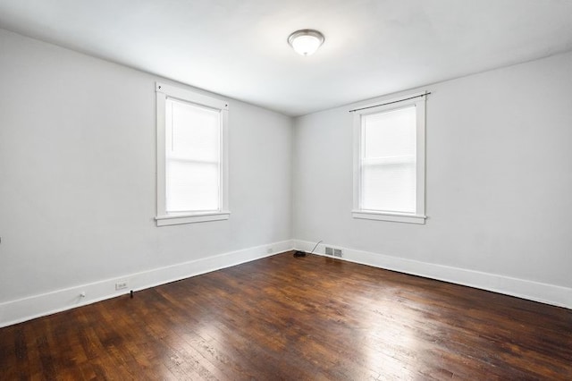 empty room featuring a healthy amount of sunlight and hardwood / wood-style floors