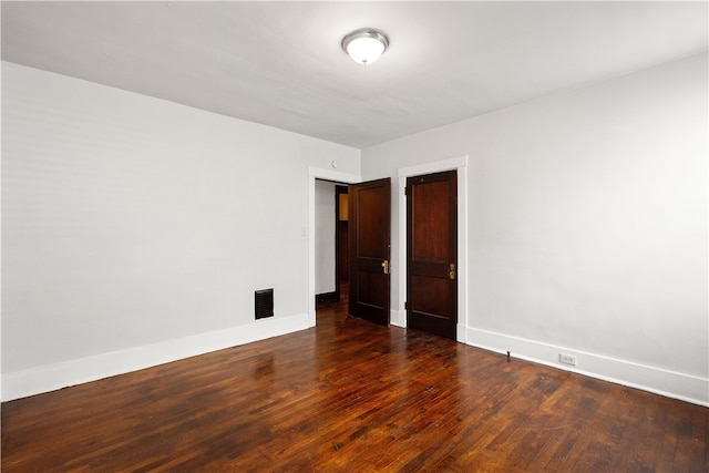 unfurnished room with dark wood-type flooring