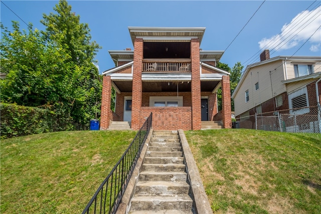 rear view of property featuring a balcony and a lawn