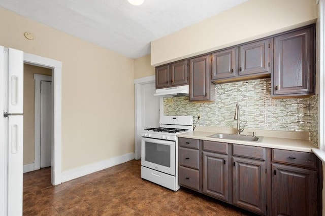 kitchen featuring backsplash, sink, white gas range, and dark brown cabinetry