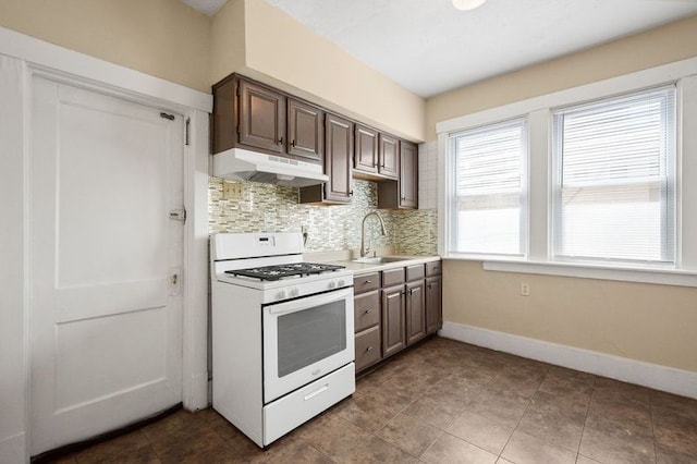 kitchen with gas range gas stove, dark tile patterned floors, sink, dark brown cabinets, and tasteful backsplash