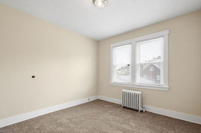 carpeted spare room featuring radiator heating unit