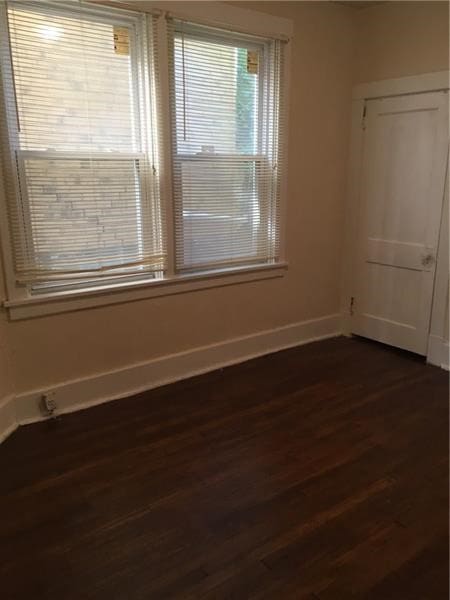 spare room with dark wood-type flooring