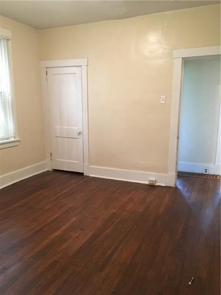 spare room featuring dark wood-type flooring