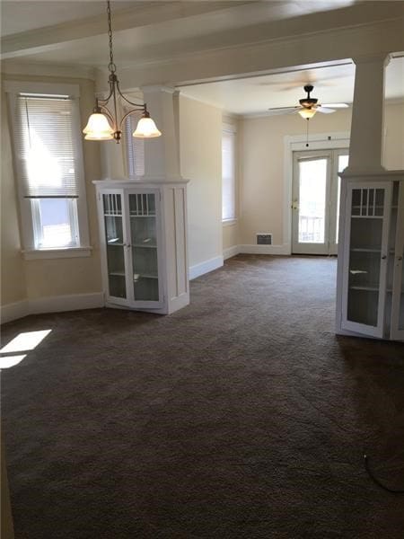 unfurnished living room with ceiling fan with notable chandelier and carpet flooring