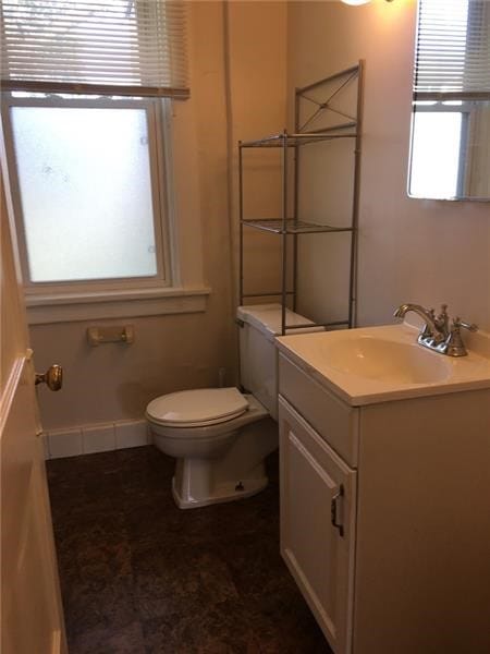 bathroom featuring vanity, toilet, and a healthy amount of sunlight