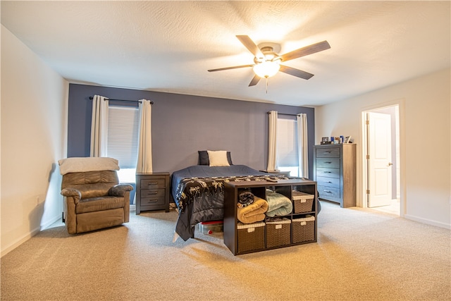 carpeted bedroom featuring multiple windows, a textured ceiling, and ceiling fan