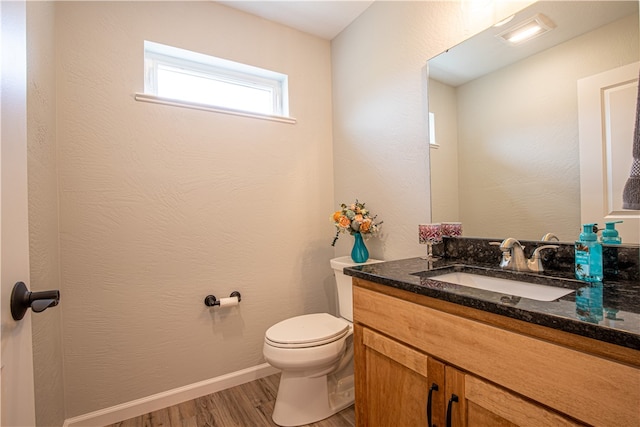 bathroom with vanity, toilet, and hardwood / wood-style flooring