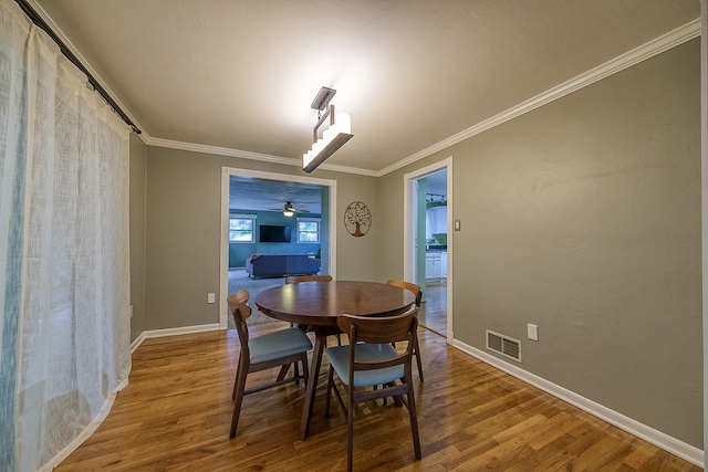 dining area with ceiling fan, ornamental molding, and hardwood / wood-style flooring