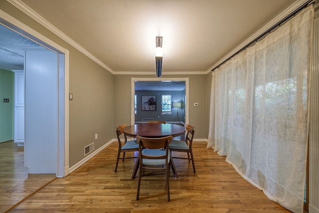 dining space with crown molding and hardwood / wood-style floors