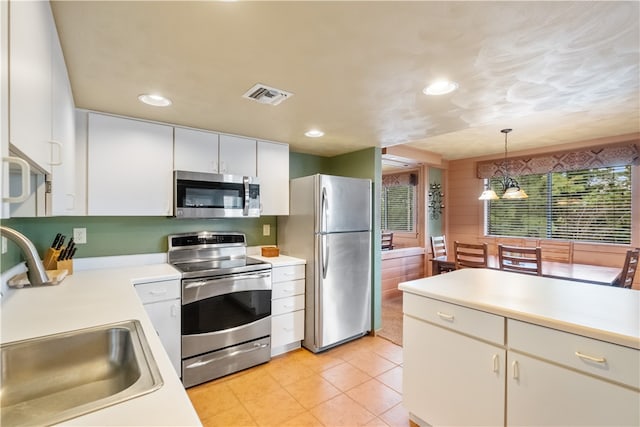 kitchen with decorative light fixtures, appliances with stainless steel finishes, light tile patterned flooring, and sink