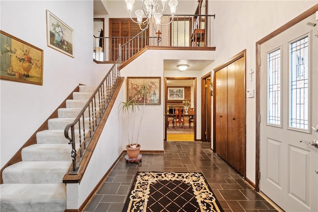 foyer featuring a healthy amount of sunlight, a towering ceiling, and a chandelier