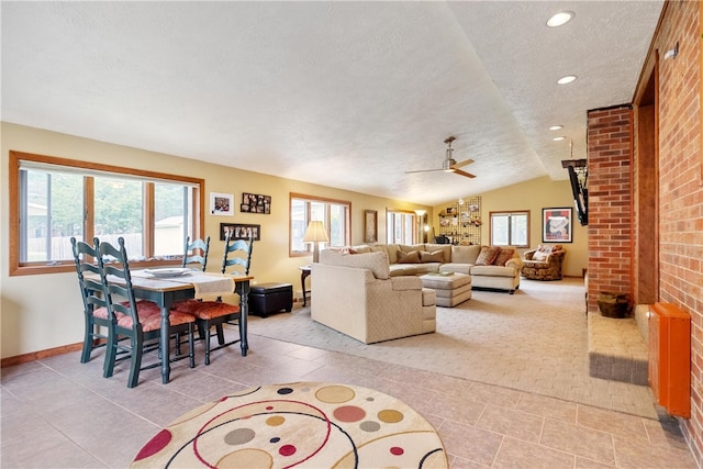 living room with ceiling fan, a wealth of natural light, a textured ceiling, and vaulted ceiling