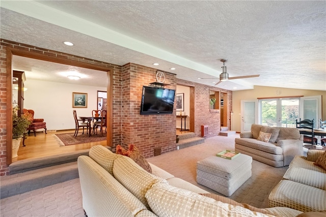 living room featuring vaulted ceiling, a textured ceiling, ceiling fan, and light hardwood / wood-style floors