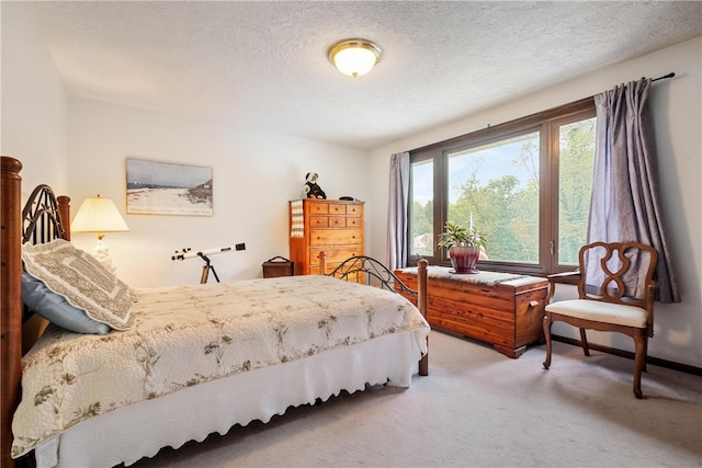 bedroom with a textured ceiling, carpet flooring, and multiple windows