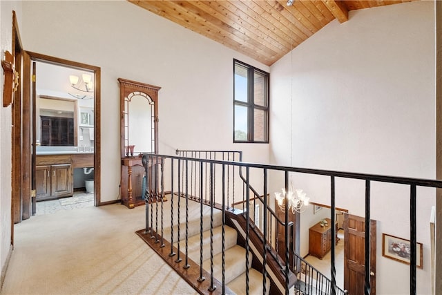 hall featuring wooden ceiling, light carpet, a notable chandelier, high vaulted ceiling, and beam ceiling