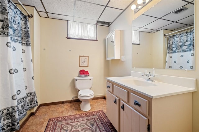 bathroom featuring walk in shower, toilet, a drop ceiling, and vanity