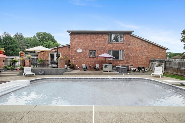 view of swimming pool with a diving board and a patio