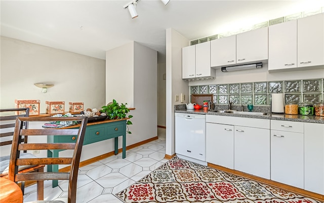 kitchen featuring dishwasher, white cabinetry, sink, light tile patterned flooring, and rail lighting