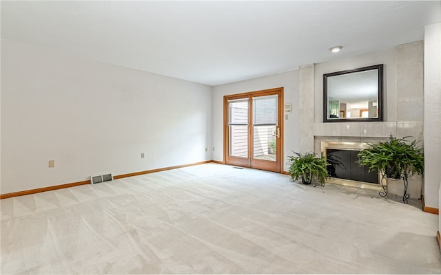 unfurnished living room with a large fireplace and light carpet