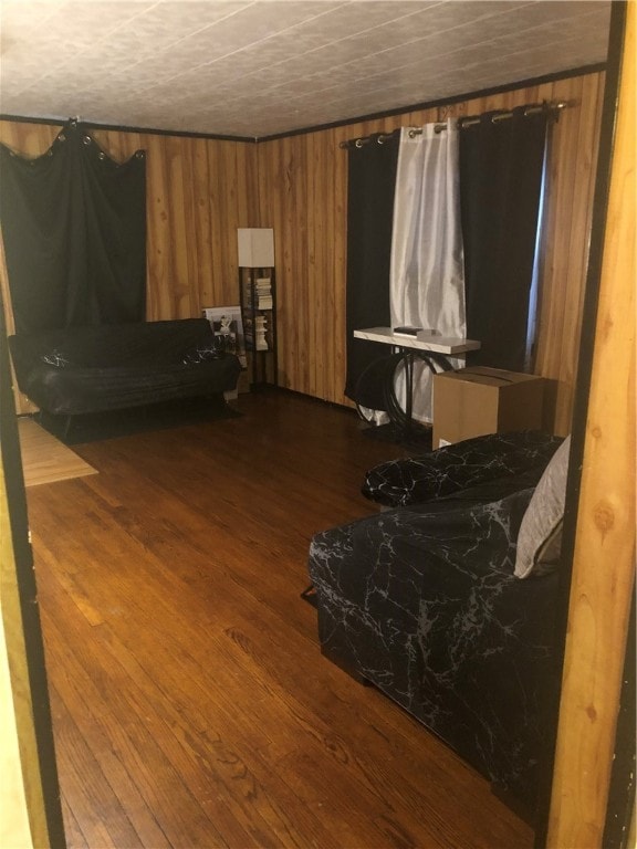 bedroom featuring hardwood / wood-style flooring and wooden walls