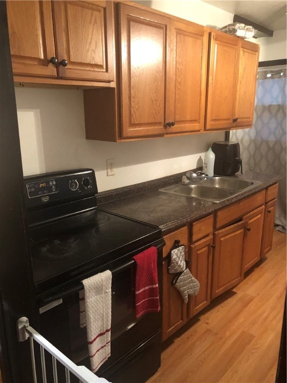 kitchen with black range with electric cooktop, sink, and light hardwood / wood-style floors