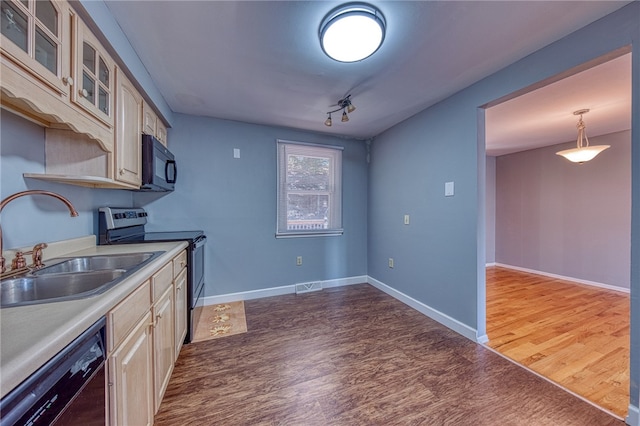 kitchen with black appliances, pendant lighting, sink, light wood-type flooring, and track lighting