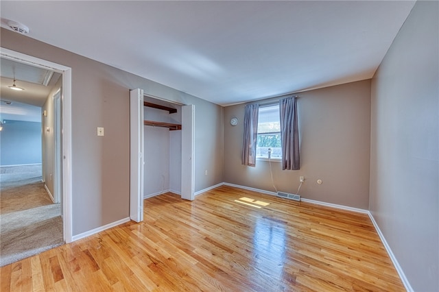 unfurnished bedroom featuring light wood-type flooring and a closet