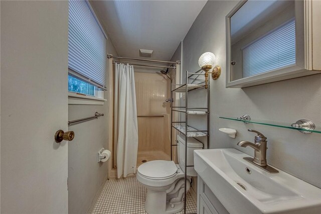 bathroom featuring vanity, toilet, walk in shower, and tile patterned flooring