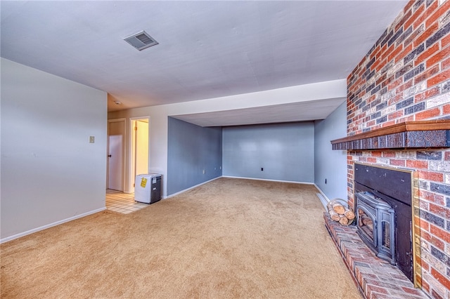 unfurnished living room with light carpet, a fireplace, and a wood stove