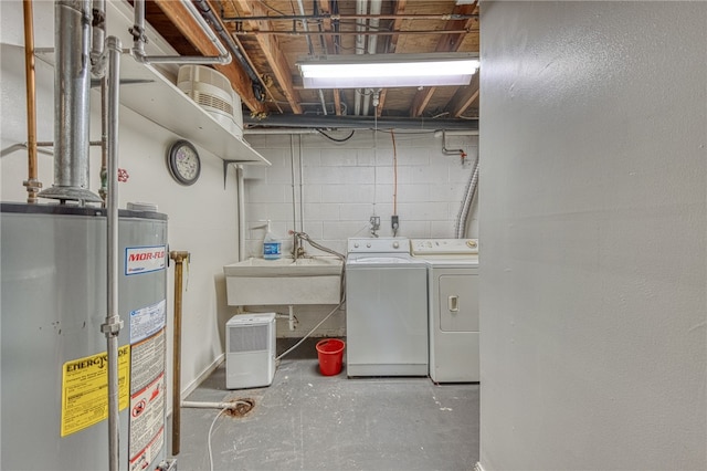 laundry room with gas water heater, washing machine and clothes dryer, and sink