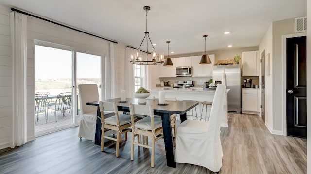 dining area featuring a chandelier and light wood-type flooring