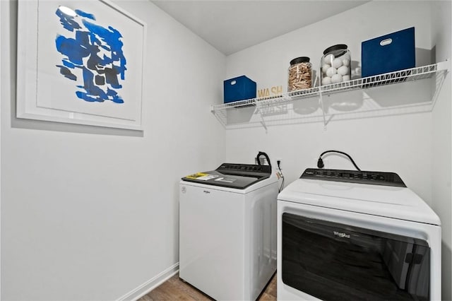 washroom featuring hardwood / wood-style flooring and washing machine and clothes dryer