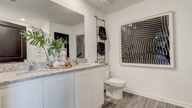 bathroom with hardwood / wood-style floors, vanity, and toilet