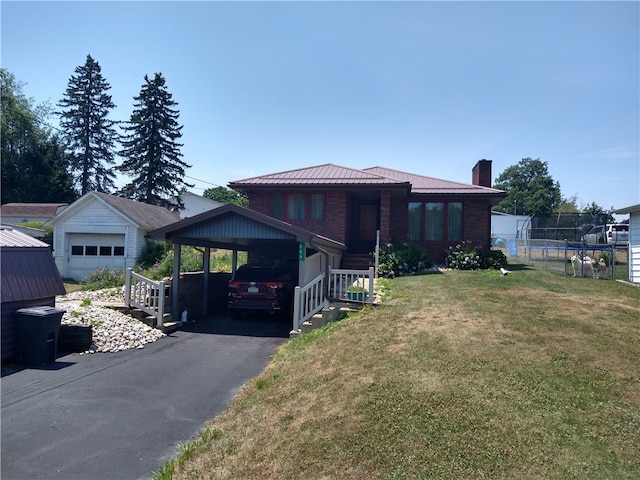 view of front of house with a front lawn, a garage, and an outbuilding