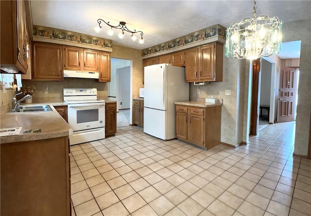 kitchen with white appliances, sink, light tile patterned floors, an inviting chandelier, and hanging light fixtures