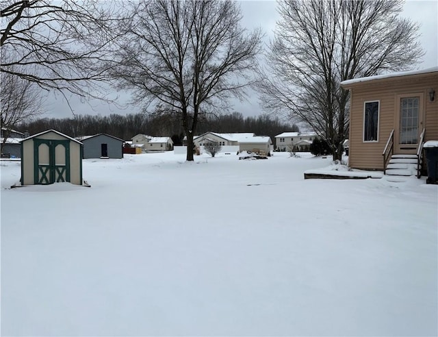 yard covered in snow with a shed