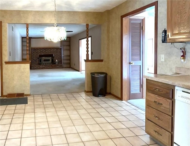 kitchen with a fireplace, white dishwasher, light colored carpet, decorative light fixtures, and a chandelier