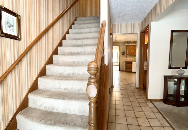 stairs featuring a textured ceiling and tile patterned floors