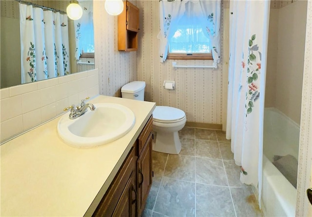 full bathroom with shower / tub combo, vanity, and toilet