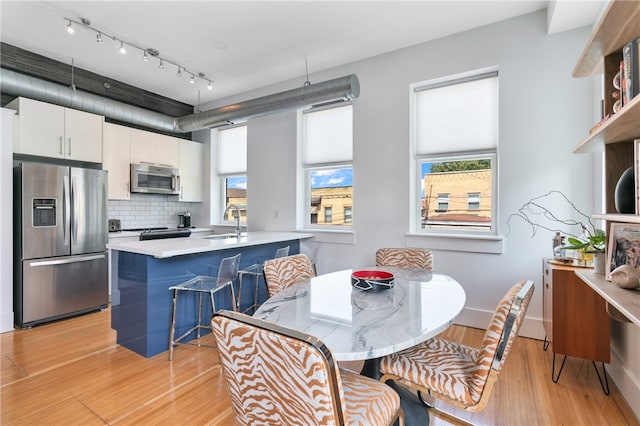 dining area with sink and light hardwood / wood-style flooring