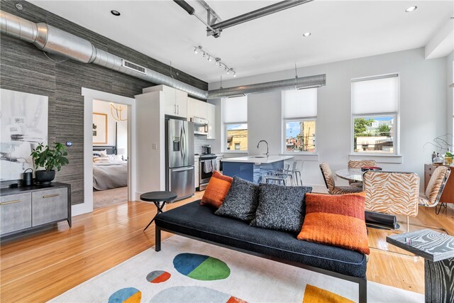 living room featuring sink and light hardwood / wood-style floors