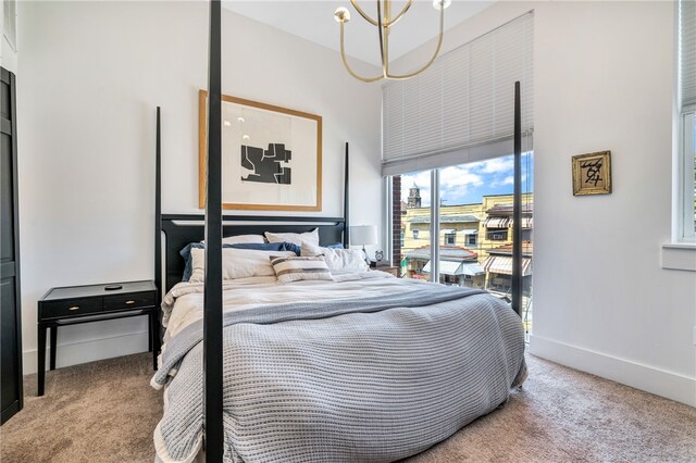 carpeted bedroom with an inviting chandelier