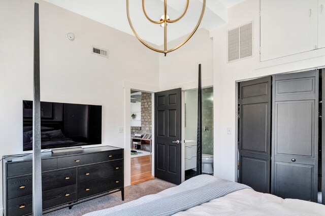 bedroom with light hardwood / wood-style flooring, a high ceiling, and a closet