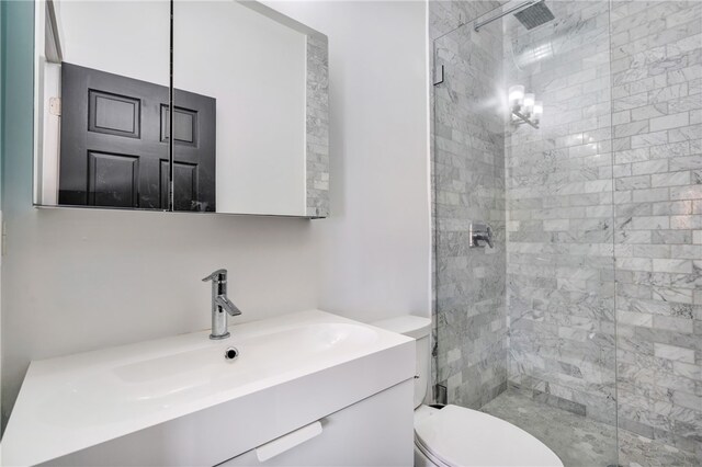 bathroom with vanity, toilet, and a shower with door