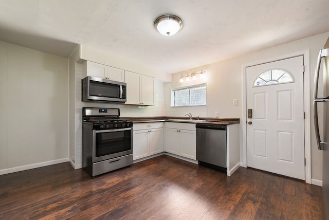 kitchen with white cabinetry, tasteful backsplash, stainless steel appliances, sink, and dark wood-type flooring