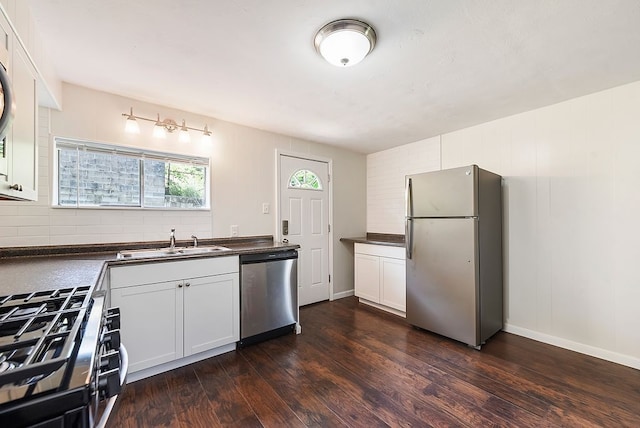 kitchen with sink, dark wood-type flooring, decorative backsplash, appliances with stainless steel finishes, and white cabinets