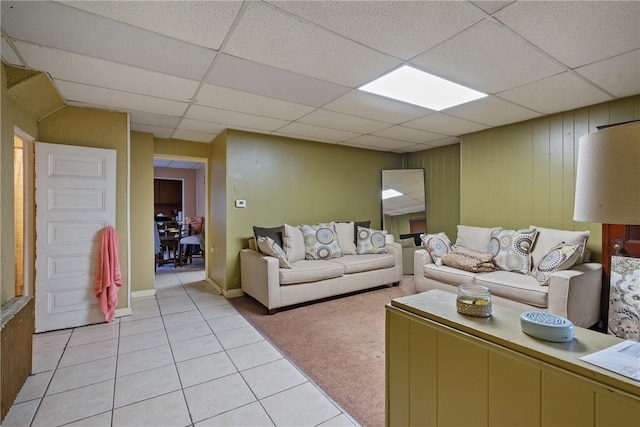 living room featuring a drop ceiling and light tile patterned floors