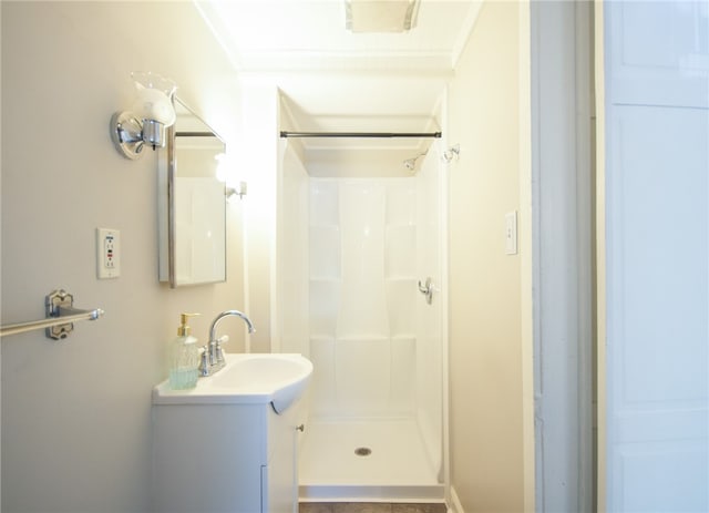 bathroom featuring crown molding, vanity, and a shower