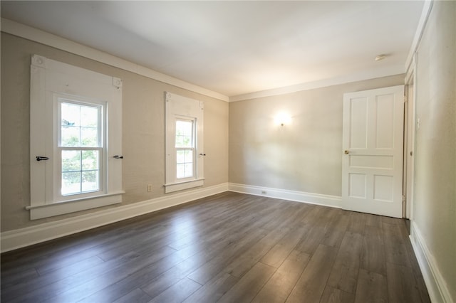 empty room featuring dark hardwood / wood-style floors and crown molding